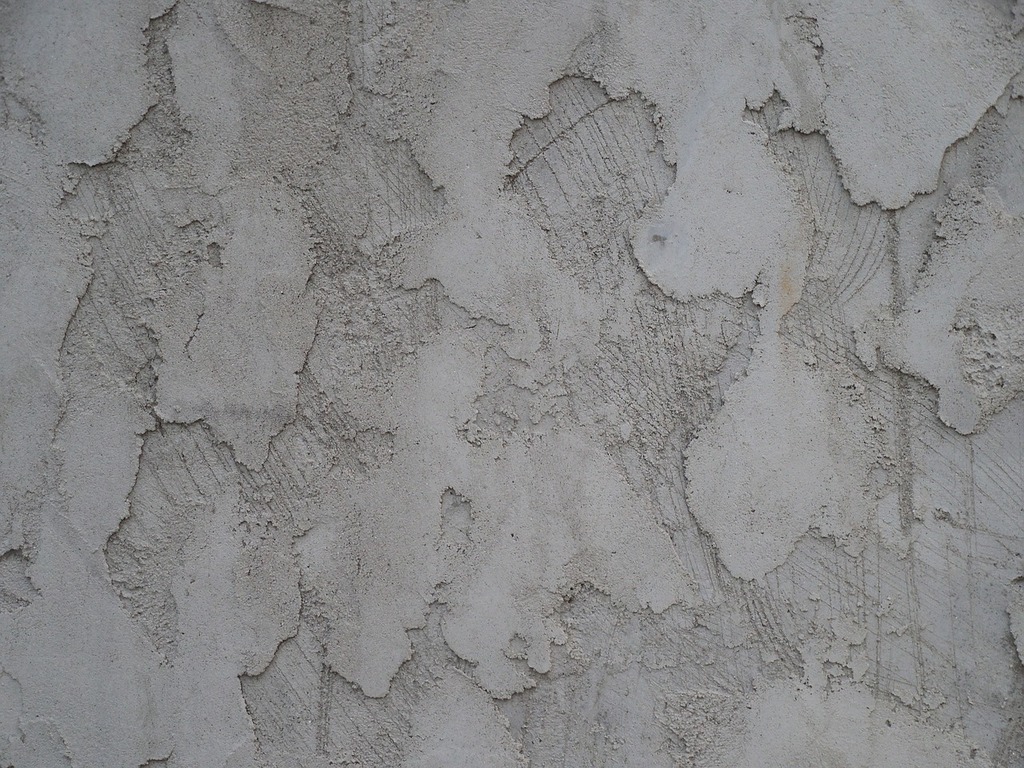 Cracked and peeling stucco wall.